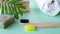 Eco natural bamboo toothbrush on green background with toiletries, natural soap, body brush and waffle towel. Zero waste