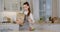 Eco shopping. Young lady in apron unpacking purchases from paper bag, putting organic vegetables to bowl at kitchen