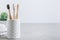 Eco toothbrushes. Bamboo toothbrushes cup, white towels on gray stone background