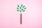 Ecological friendly, sustainable environment, Eco conscious concept with pen in the form of a tree trunk with green leaves on pink