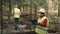 Ecologist man in workwear and helmet clean plastic garbage in forest