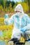 Ecologist with tools and flasks taking water samples from a forest lake for research