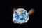 Ecology Concept : Hand holding blue planet earth globe in dark light.