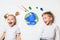 Ecology concept with two prety little kids painting earth on white background