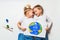 Ecology concept with two prety little kids painting earth on white background