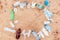 Ecology template. Frame from plastic dirty bottles with copy space on a sandy beach. Top view. The concept of