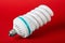 Economic light bulb standing on red background