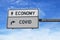 Economy versus COVID. White two street signs with arrow on metal pole. Directional road. Crossroads Road Sign, Two Arrow. Blue sky