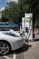 Ecotricity electric car recharging point at motorway service station with white car plugged in and charging