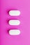 Ecstasy pills in a row on a pink background, isolate