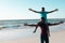 Ecstatic african american father carrying son on shoulders at beach against sea and clear sky