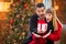 Ecstatic Mixed Race Couple Sharing Christmas In Front of Decorated Tree.