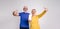 Ecstatic senior couple screaming and pointing at blank screen of mobile phone over white background