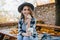 Ecstatic white woman in casual shirt holding cup of tea on blur autumn background. Outdoor photo of interested european