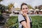 Ecstatic white woman gently touching her face while posing on nature background. Outdoor photo of fascinating lady