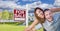 Ecstatic Young Military Couple In Front of Home with For Sale Sign