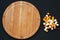 Edam and mimolette cheese with round bamboo board on dark background. Copy space, top view.
