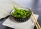 Edamame beans in a bowl with wooden chopsticks. Fresh and healthy green soybeans