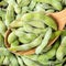 Edamame unripe soybeans in pod in spoon closeup