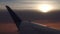 Edge of airliner wing against cloudy sunset. 4k aerial video