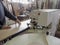 Edge banding machine. Coils of furniture finishing edges plastic band for banding machines. A worker pastes an edge on the machine