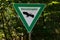 At the edge of the forest there is a green sign on a hiking trail. Nature reserve.