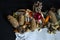 Edge of the paper napkin with pine cones, pine twig, old Christmas decorations, almonds and orange peel on black background