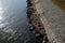 Edge of the river bank reinforced with giant stones as a breakwater against erosion of stone paving at the dock cobblestone promen