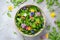 Edible flowers salad in a ceramic bowl on a grey background
