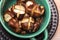 Edible roasted chestnuts in a green bowl