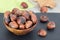 Edible roasted chestnuts in wooden bowl over green napkin.