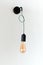 Edison retro lamp. Incandescent bulb on white wall background in loft. Concept of vintage style