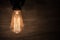 Edison vintage light bulb, retro light bulb in dark room and concrete wall as background
