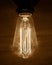 Edison vintage light bulb, retro light bulb in dark room and concrete wall as background