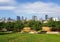 Edith Wolfson Park. Alley, wooden benches and green trees. Distance view from grassy park hill on Tel Aviv and  Ramat Gan