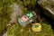 Edole, Latvia - August 28, 2015: Open geocaching container - glass jar with logos next to mossy stones