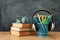 Education and back to school concept. headphones, books and pencils in front of classroom blackboard