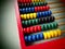Education concept - abacus with many colorful beads. Red, blue, green, black, yellow details on the abacus. Mathematical exercises