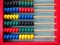 Education concept - abacus with many colorful beads. Red, blue, green, black, yellow details on the abacus. Mathematical exercises