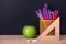 Education concept with green apple, ruler or triangle, felt pens