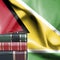 Education concept - Stack of books and reading glasses against National flag of Guyana