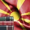Education concept - Stack of books and reading glasses against National flag of Macedonia