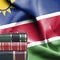 Education concept - Stack of books and reading glasses against National flag of Namibia