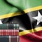 Education concept - Stack of books and reading glasses against National flag of Saint Kitts and Nevis