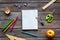 Education concept with stationery of student with notebook, pens, clock on wooden background top view