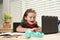 Education and distance learning for kids, homeschooling. School child watching online education class on the internet at