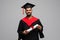 education, graduation and people concept - happy smiling indian male graduate student in mortar board and bachelor gown with