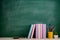 Education and reading concept - group of colorful books on the wooden table in the classroom, blackboard background