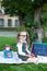 Education and school concept. Preschool education. Happy little preschool child girl with red apple sitting in the park for lunch.