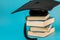 Education and science concept.Graduation Cap with a stack of books.Books with covers stack and student hat on blue